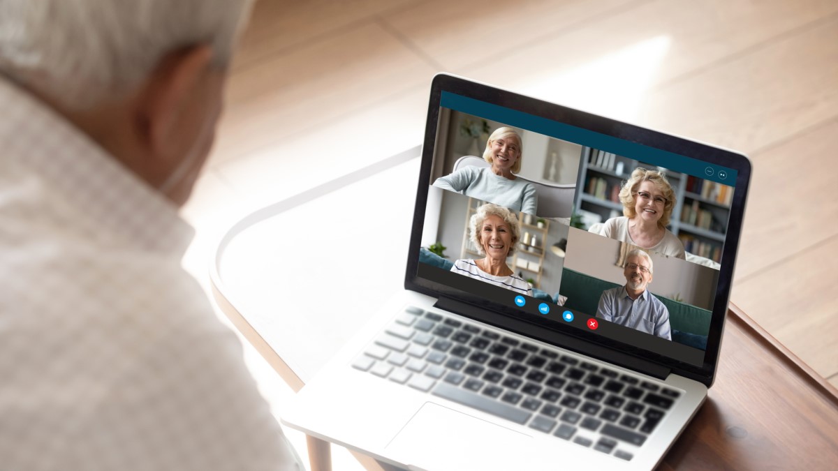 Older man talking to friends on laptop via Zoom call