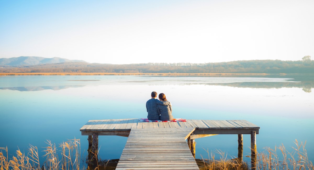 Couple with back to camera, looking out over lake