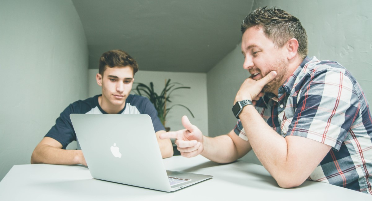 Two younger men looking at a laptop screen