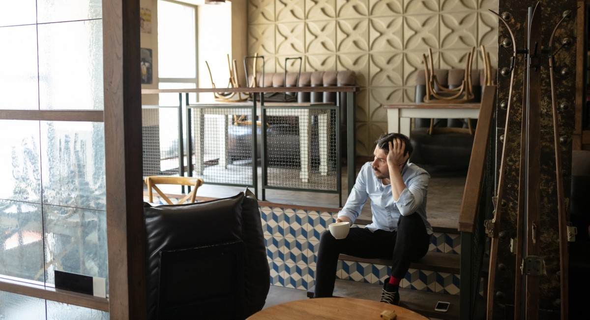 Man sitting on stairs with cup of coffee