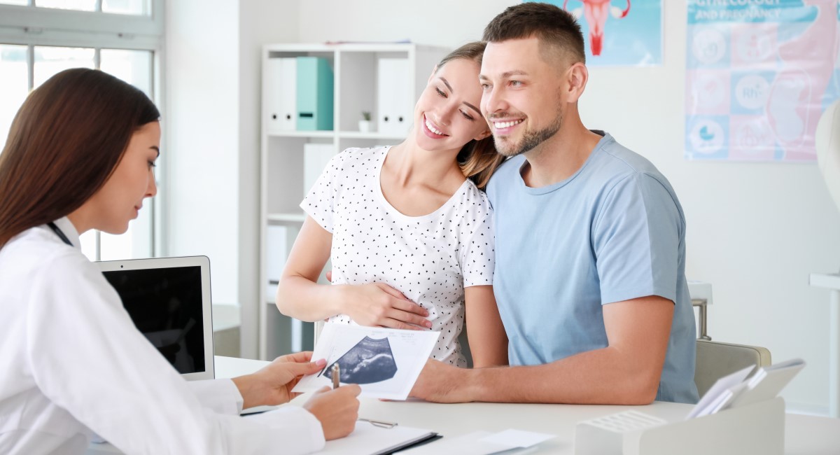 Pregnant woman and partner talking to their doctor
