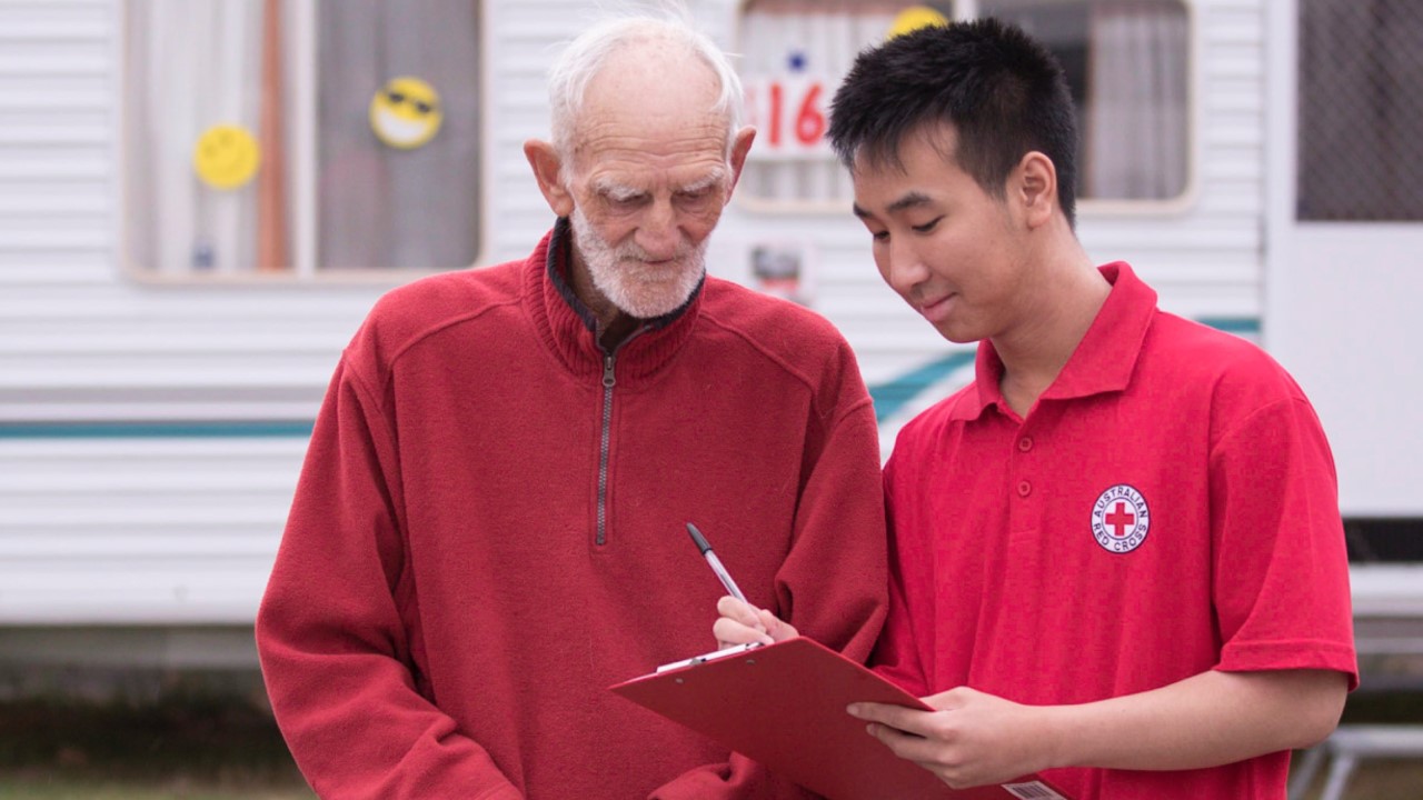 Red Cross volunteer helping elderly man