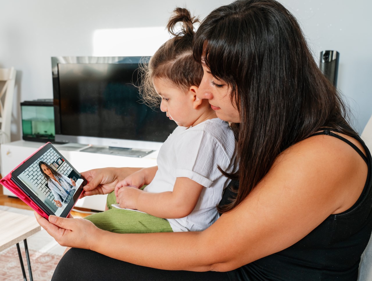 Mother and young child looking at computer screen during a telehealth session