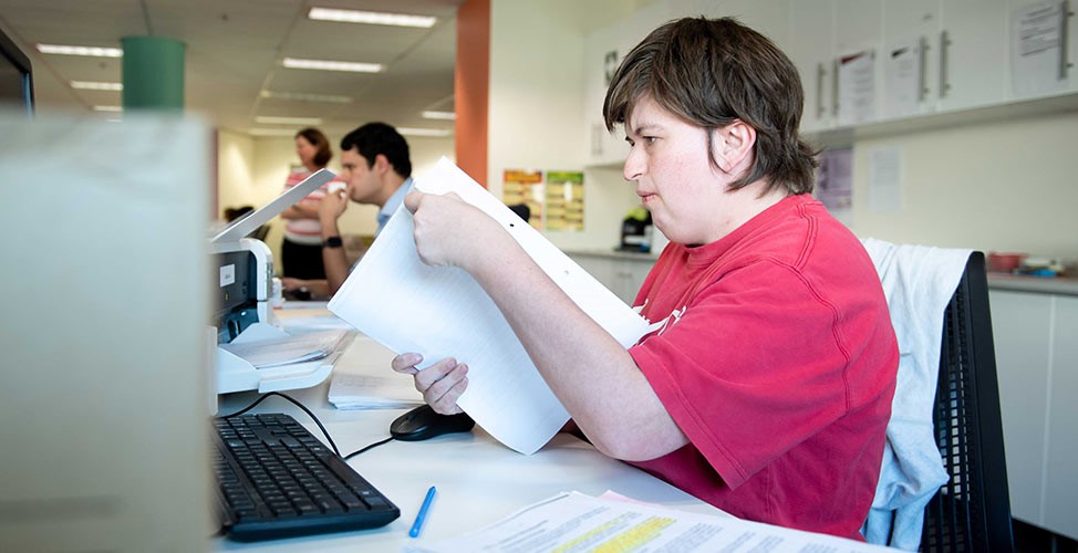 A Jigsaw employee performing computer and paperwork