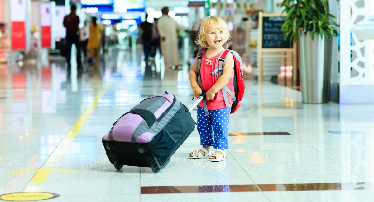 Small child with suitcase at airport