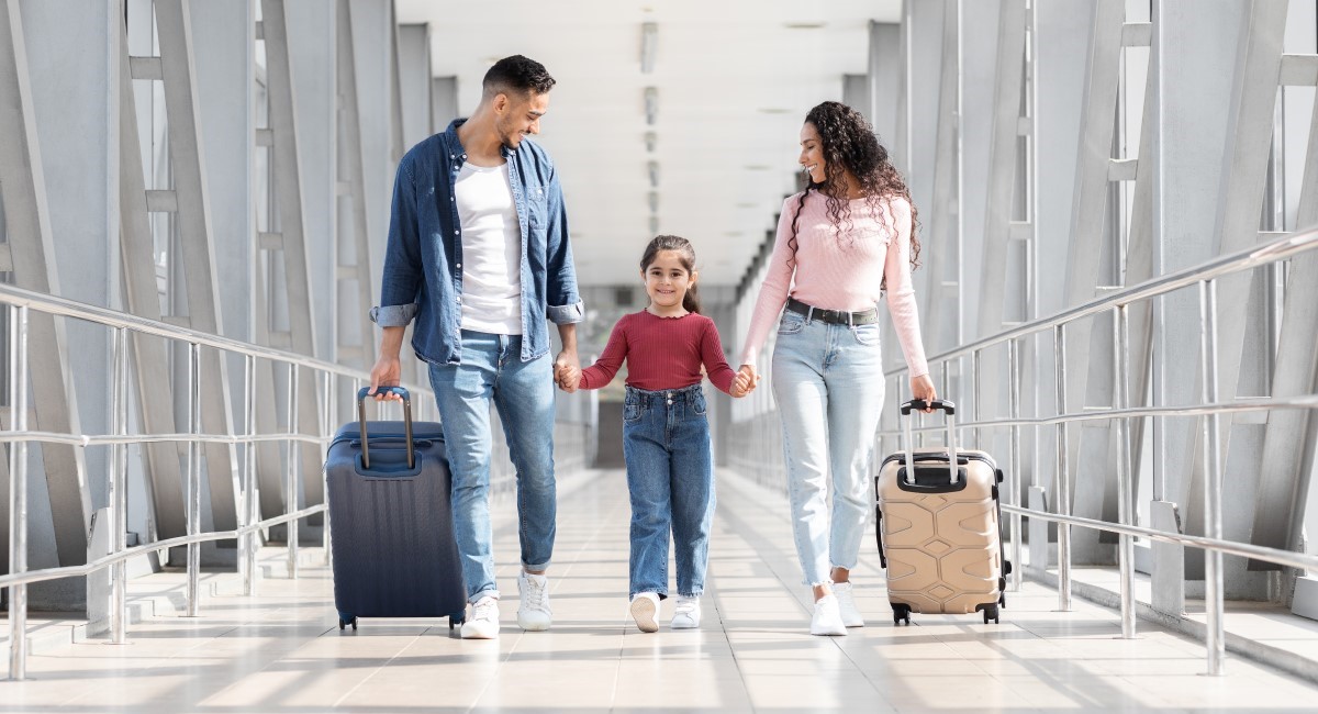 Mother and father at airport with smiling daughter