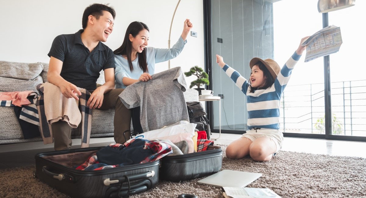 Young child looking happy about going on holiday with parents