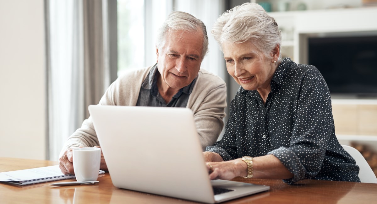 Elderly man and woman looking at laptop