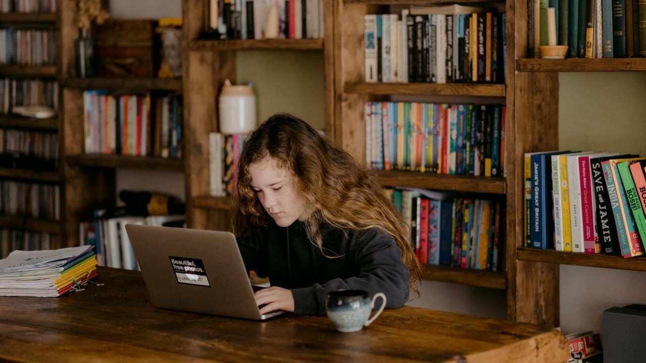 Younger woman looking at a laptop in library