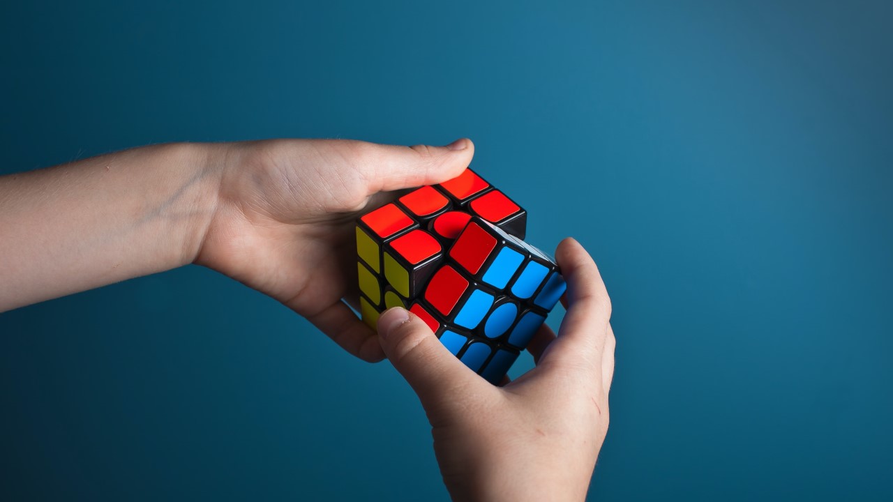 close-up of hands solving rubik's cube