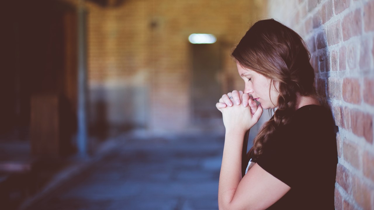 Woman with clasped hands looking stressed