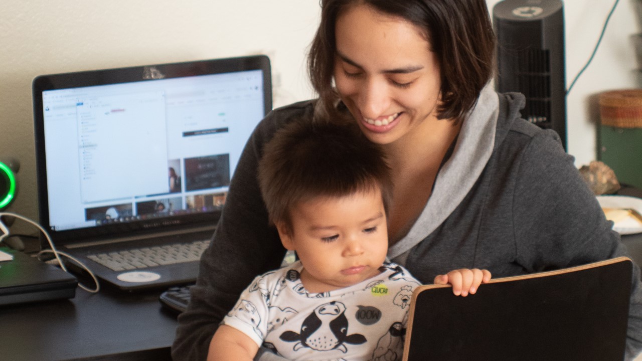 Woman working from home with child in her lap