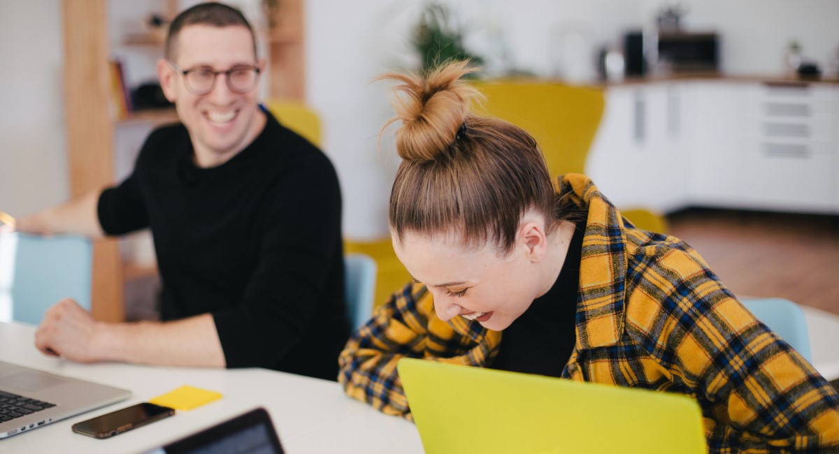 Woman laughing with male co-worker