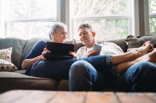 Man and woman on couch, looking at tablet