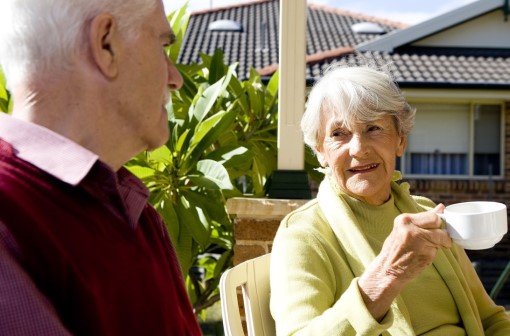 Elderly man and woman enjoying a cup of tea outside