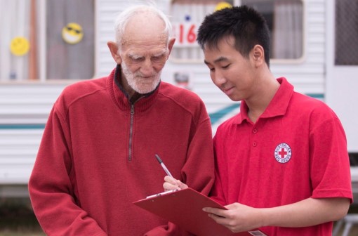 Elderly man with a Red Cross volunteer