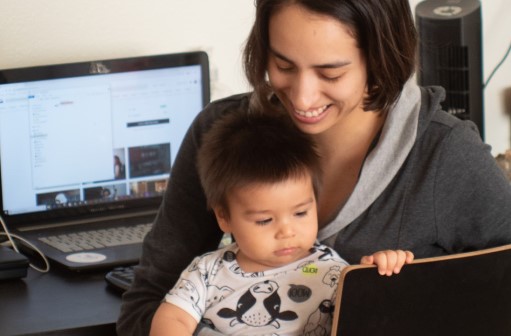 Mother working from home with toddler in lap