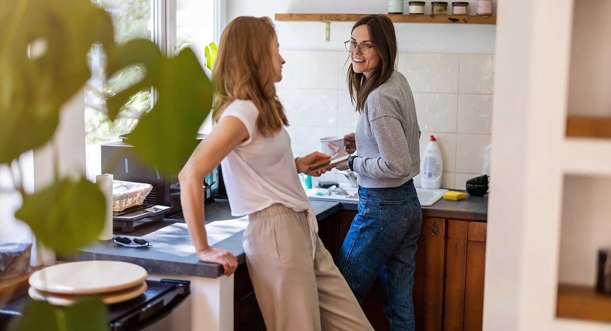 Two women talking while washing the dishes.