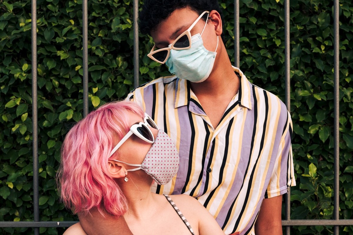 Younger man and woman wearing surgical masks