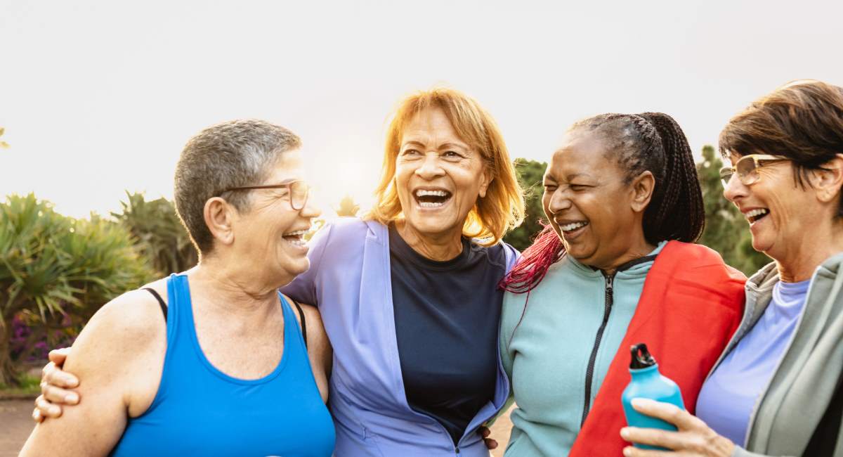 Happy multiracial senior women having fun after workout exercises in the park