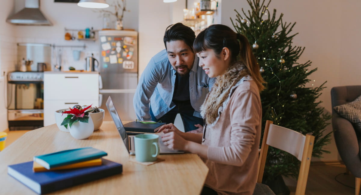 A young couple looking at something on a laptop