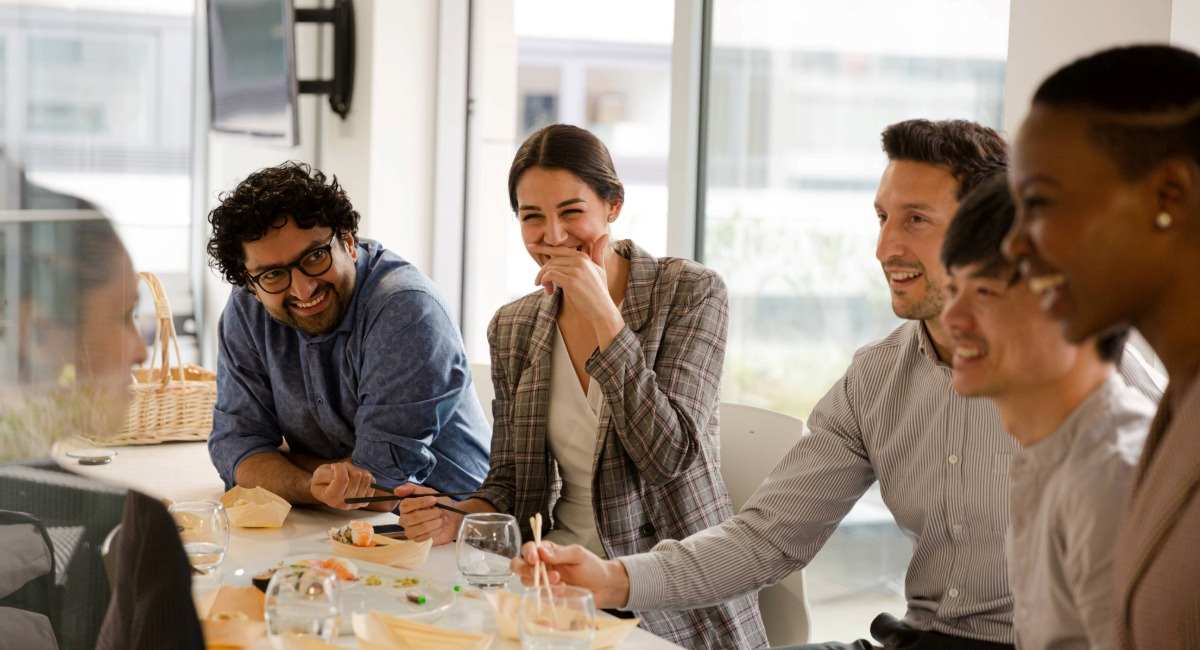 A group of professional colleagues laughing while having lunch