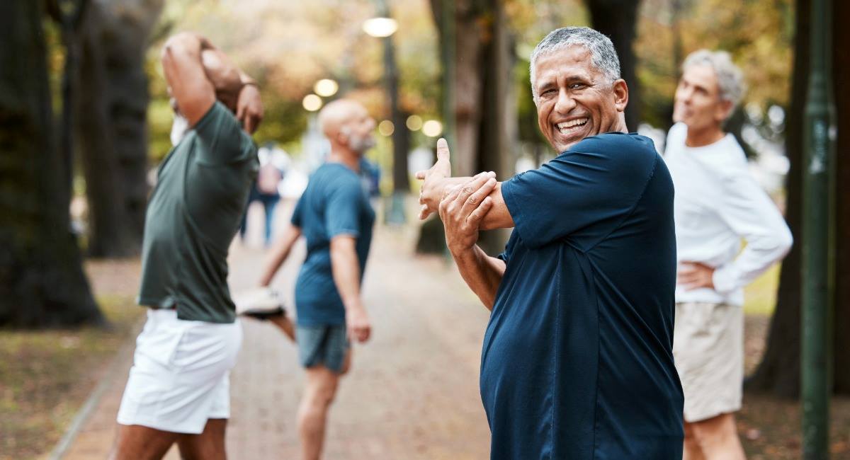 A middle aged man stretching with a running group
