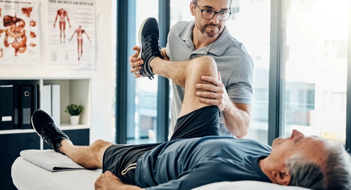A man talking to his doctor while rubbing his shoulder