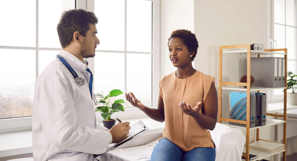 A young woman talking seriously with an attentive health practitioner
