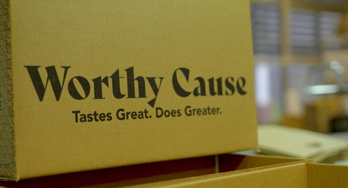 A cardboard box with the Worthy Cause logo and slogan