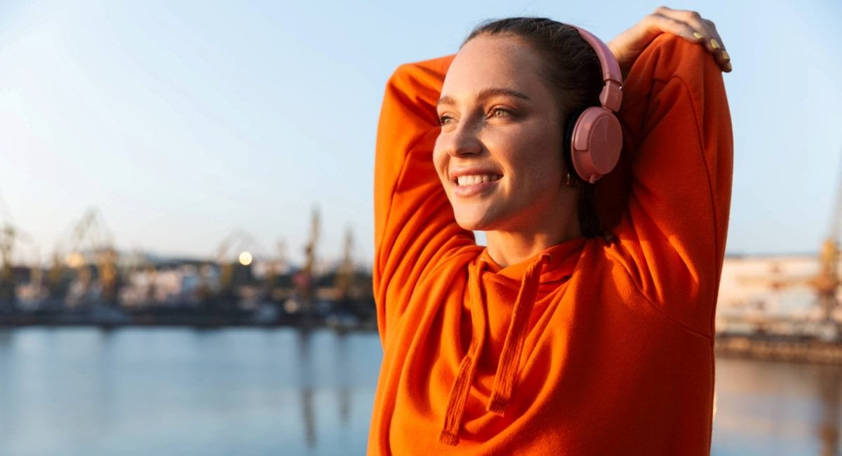 A young woman smiling while stretching before going for a run