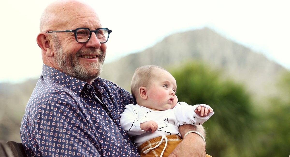 Smiling grandfather holding baby grandchild