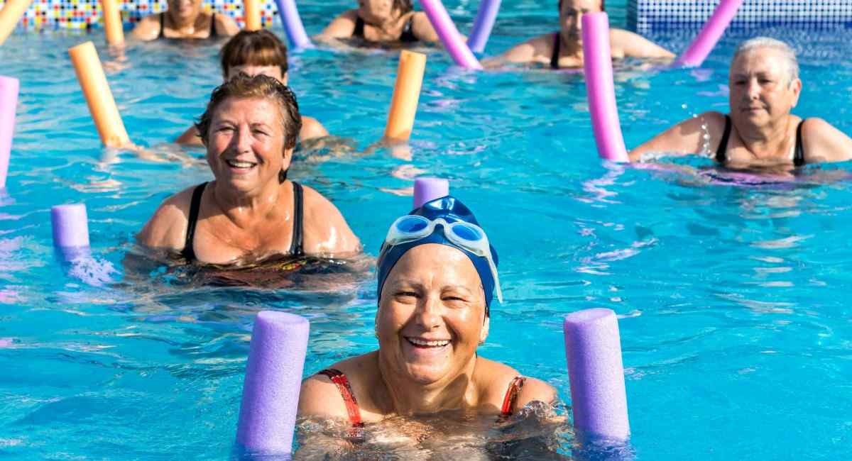 A group of mature women taking part in a water aerobics class