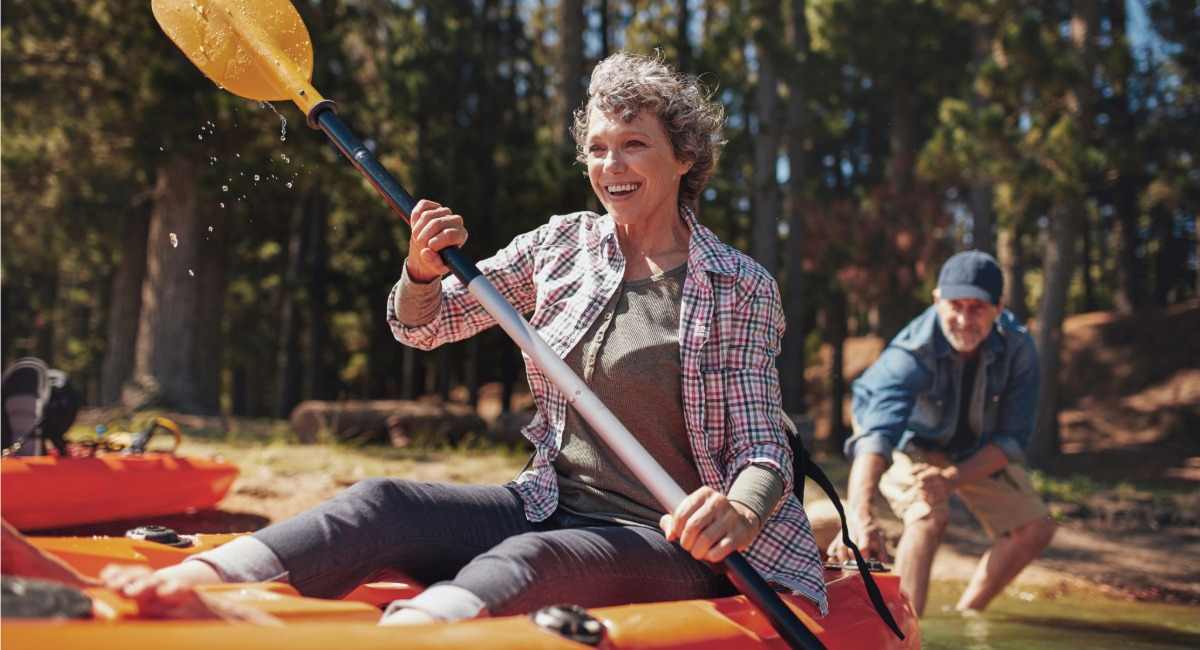 A woman smiling while kayaking in a river
