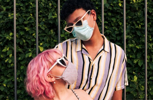Younger man and woman wearing surgical masks
