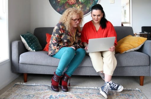 Two women having a discussion on a couch