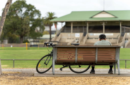 A man sitting by himself on a bench outside