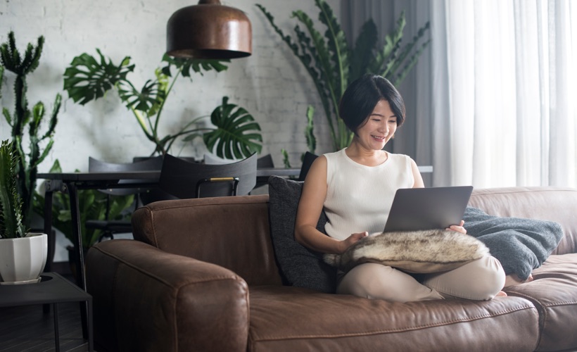 Lady sitting on the couch using her laptop